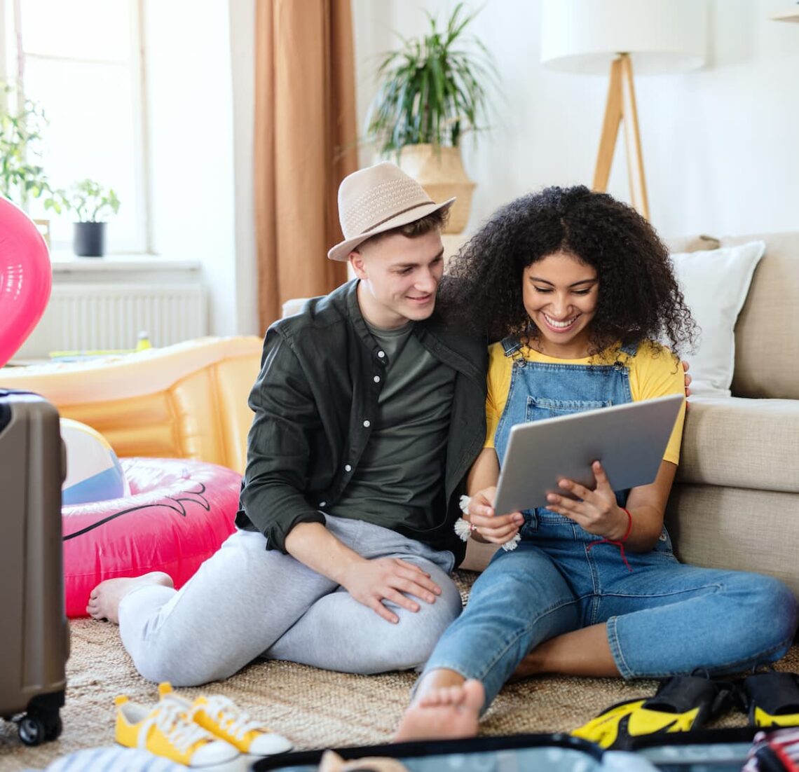 young-couple-with-tablet-packing-for-holiday-at-ho-2021-09-02-08-00-34-utc